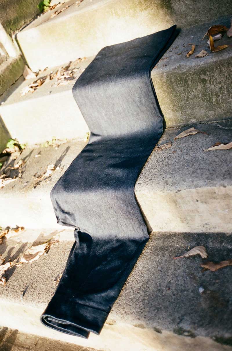 Dunkle Jeans über Stufen einer Treppe gefaltet